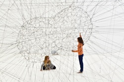 Young people in a futuristic construction made of cords
