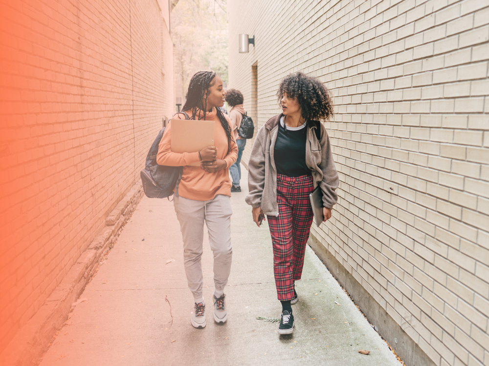 Two young people talking to one another and walking towards the camera