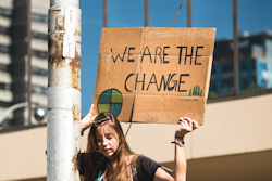 Climate activist holding sign that reads 'We are the change'