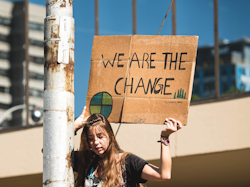 Climate activist holding sign that reads 'We are the change'
